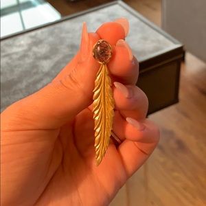 Hanging black and gold feather earrings.